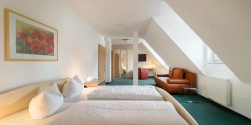 Habitación blanca con 2 camas y silla en Haus Hufeland, en Bad Salzungen