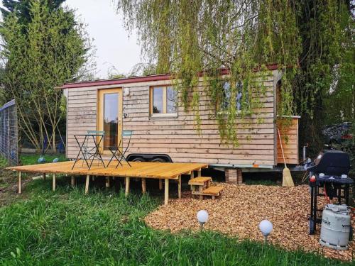 ein winziges Haus mit einem Picknicktisch davor in der Unterkunft Schäferwagen Hygge nähe Reuss in Gisikon