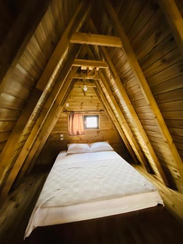 a bed in the attic of a wooden house at NOEL BUNGALOV & CAFE in Demre