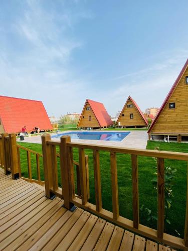 a wooden deck with a yard with houses at NOEL BUNGALOV & CAFE in Demre