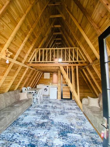 a large attic room with a couch and a table at NOEL BUNGALOV & CAFE in Demre