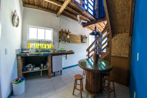 a kitchen with a counter and a table and stools at Verde Vida Ecopousada - Termas do Gravatal in Gravatal