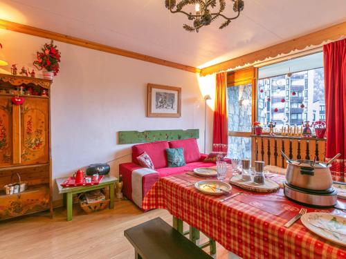 un salon avec un canapé rouge et une table dans l'établissement Coquet appartement montagnard proche commodités - FR-1-694-35, à Val dʼIsère