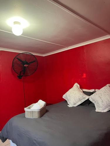 a red room with a bed with a red wall at Grey house lodge in Pietermaritzburg