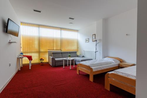 a room with a couch and a bed and a table at Apartmani i sobe Castra in Banja Luka