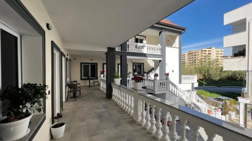 un balcón de una casa con barandillas y plantas blancas en VILA AARON en Durrës