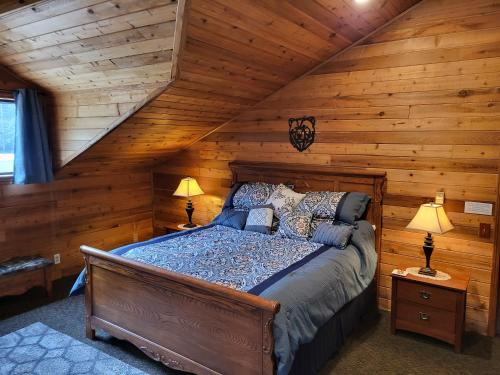 1 dormitorio con 1 cama en una cabaña de madera en Hidden Bear Retreat Center en Clark Fork