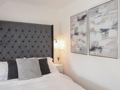 a bedroom with a bed with a black padded headboard at Fore Street House - Apartment 3 in Seaton