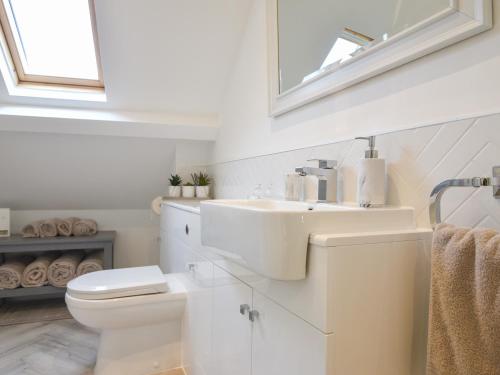 a white bathroom with a sink and a toilet at Fore Street House - Apartment 3 in Seaton