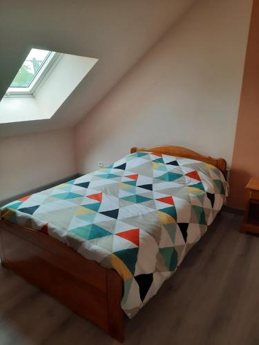 a bedroom with a bed with a colorful quilt at Chambres circuit 24 h du Mans in Cérans-Foulletourte
