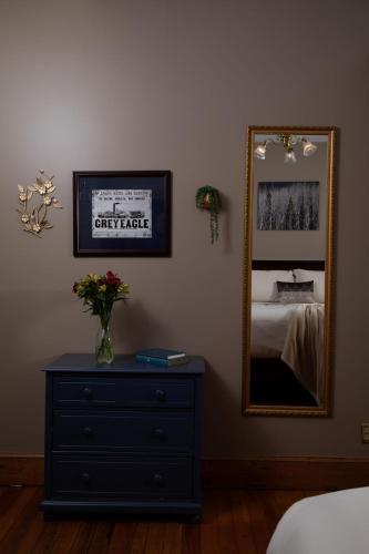 a bedroom with a dresser and a mirror at Riverboat Suites in Galena
