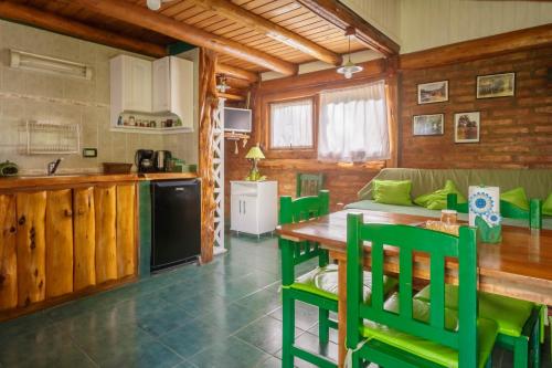 cocina y sala de estar con mesa y sillas en Cabañas Kairós en El Bolsón