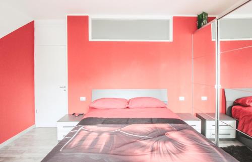 - une chambre avec des murs rouges et un lit avec des oreillers roses dans l'établissement Casa Camilla, à Dascio