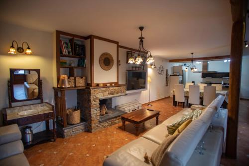 Casa Ría de Navia في نافيا: غرفة معيشة مع أريكة ومدفأة