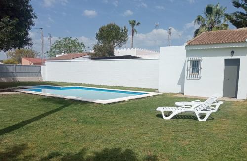 einen Hof mit einem Pool und einem weißen Haus in der Unterkunft Casa Rural El Algarrobo in Utrera