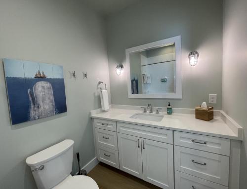 a bathroom with a toilet and a sink and a mirror at Key West Cottages in Chincoteague