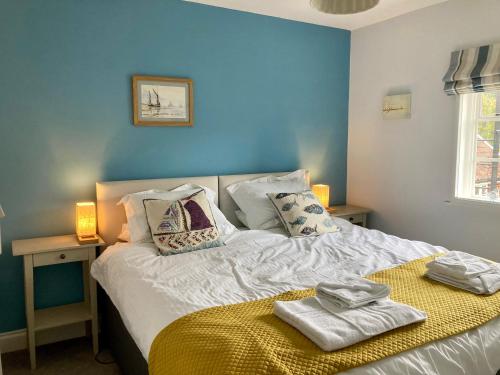 a blue bedroom with a bed with towels on it at House On The Hill in Framlingham