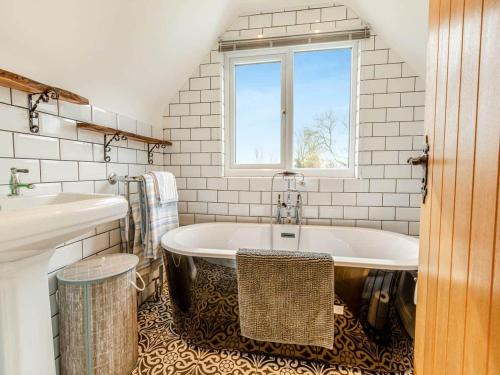a bathroom with a tub and two sinks and a window at Bluebell House 5 Star Holiday Let in Somerton