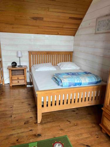 une chambre avec un lit dans une pièce en bois dans l'établissement Kerletty, la mer, les embruns, à 250 m des plages, à Plouguerneau
