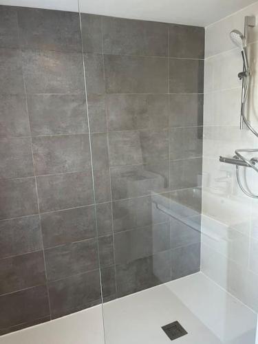 une douche avec une porte vitrée dans une salle de bain dans l'établissement Kerletty, la mer, les embruns, à 250 m des plages, à Plouguerneau