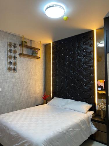a bedroom with a large bed with a black headboard at Batam Three Bedrooms Apartment - One Residence 2AG - in Batam Center