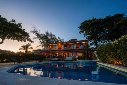 a house with a swimming pool in front of it at Maravista Hotel & Spa Ltda in Búzios