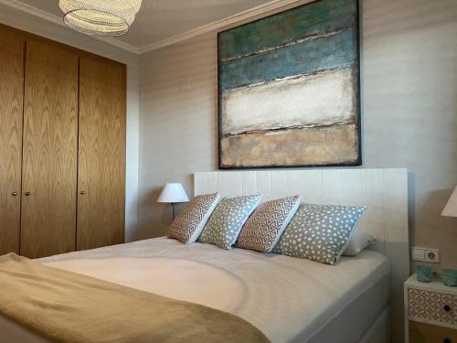 a bedroom with a bed with a painting above it at Residencial Mar de Denia 2 in Denia