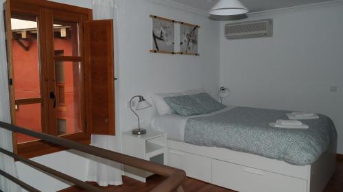 a small bedroom with a bed and a staircase at GEINTUR TOLEDO EXCLUSIVE HERITAGE in Toledo