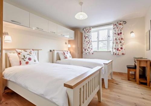 a bedroom with two beds and a window at Orchard View in Gilwern