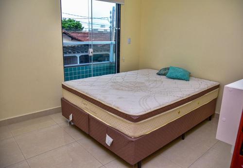 Postelja oz. postelje v sobi nastanitve Casa com Wi-Fi a 400 metros da Praia Maracanã-SP