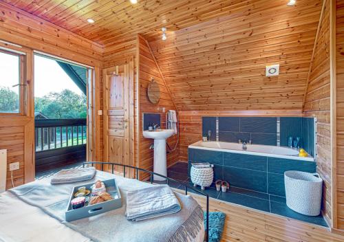 a wooden bathroom with a tub and a sink at Pumpkin Lodge in Menai Bridge