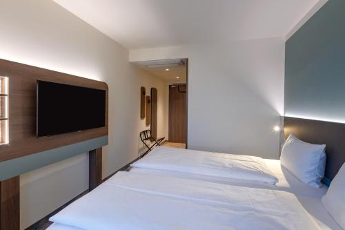 a hotel room with a bed with a flat screen tv at ibis Styles Kiel City in Kiel