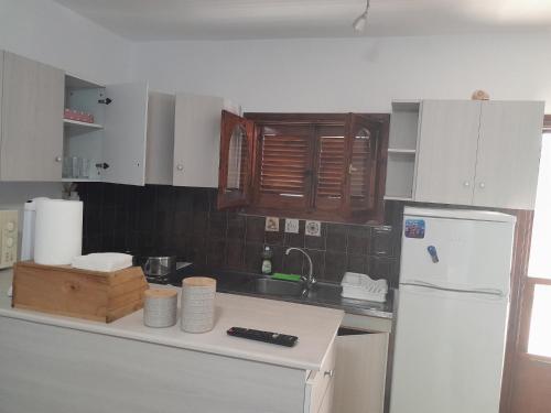 a kitchen with white cabinets and a white refrigerator at Olympian Chalet in Paralia Katerinis