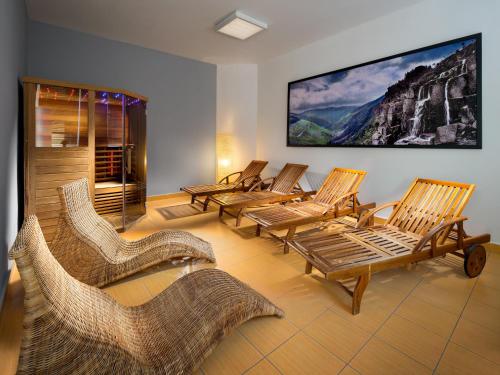 a group of chairs in a room with a large screen at Pinia Hotel & Resort in Špindlerův Mlýn