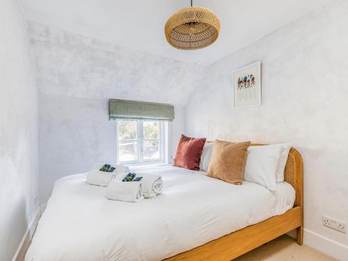 a bedroom with a large white bed with a window at Charming Downland Cottage - Pass the Keys in Chichester