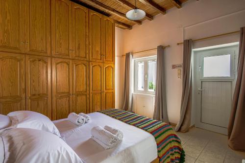 - une chambre avec un lit et des serviettes dans l'établissement Eva House Dryos Beach Paros, à Drios