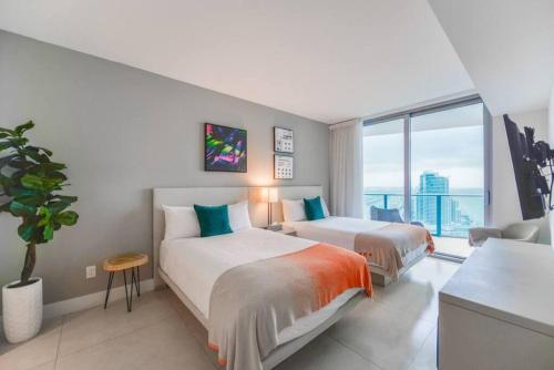 a bedroom with two beds and a large window at Stunning Condo 2/2 At Hyde BeachResort Beach Front in Hollywood