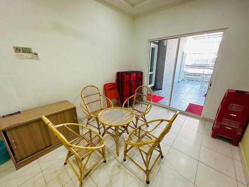 - une table et des chaises dans une chambre avec fenêtre dans l'établissement Paddy Village Multi Homestay, à Sekinchan