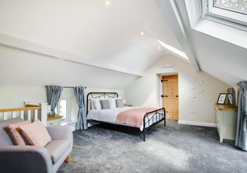 1 dormitorio con 1 cama y 1 sofá en Stabal Bodran, en Llanfair Talhaiarn
