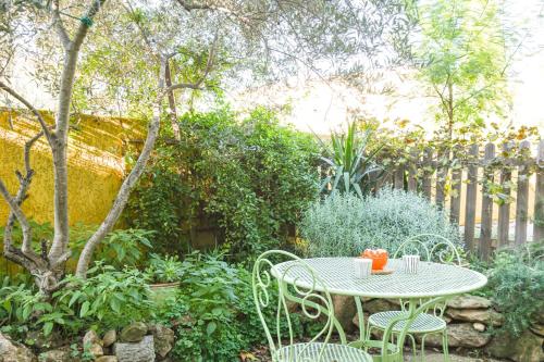 d'une table et de chaises dans le jardin. dans l'établissement Le Cabanon - Maison 2 ch avec jardin et parking, à Marseille