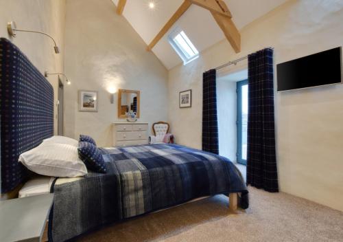 a bedroom with a bed and a television in it at Tyddyn Iago in Llangwnadl