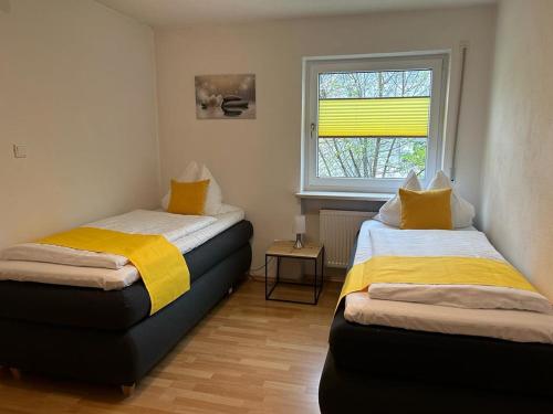 two beds in a room with a window at Schöne helle Ferienwohnung in Waldnähe in Berching