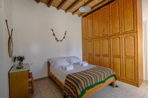 a bedroom with a bed and a wooden cabinet at Eva House Dryos Beach Paros in Drios