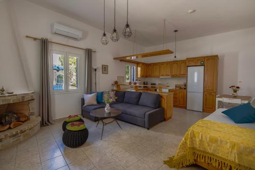 a living room with a blue couch and a kitchen at Eva House Dryos Beach Paros in Drios