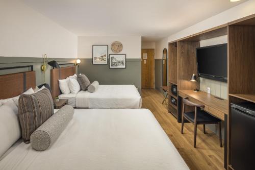 ein Hotelzimmer mit 2 Betten und einem Schreibtisch in der Unterkunft River Canyon Lodge in Moab
