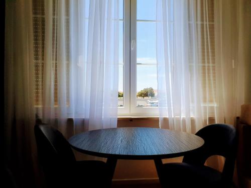 una mesa y sillas frente a una ventana en Accommodation Iva, en Zadar