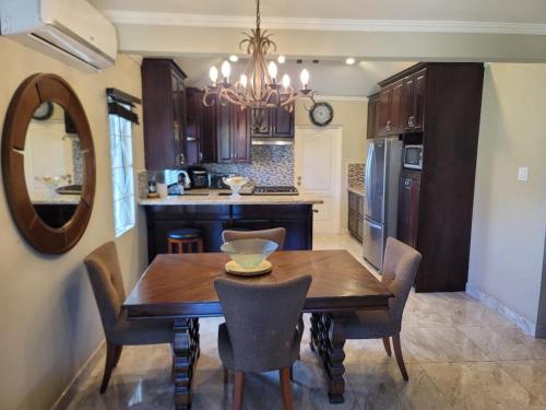 a kitchen with a wooden table and chairs and a mirror at Soleil House with a View in Priory