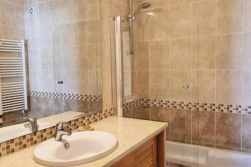 La salle de bains est pourvue d'un lavabo et d'une douche. dans l'établissement Fantástico T2 vista mar e golfe e terraço privado, à Vau