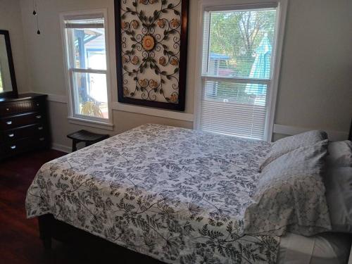 a bedroom with a bed and two windows at Bungalow Haven in Winter Haven