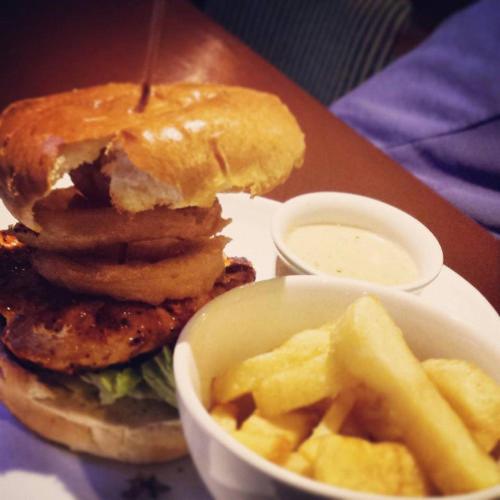 a plate with a sandwich and fries and a bowl of sauce at The Derg Arms B&B in Castlederg